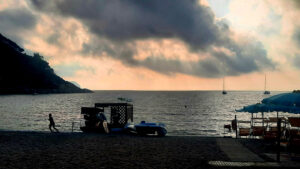 Il tramonto al mare, una persona sta correndo sul bagnasciuga