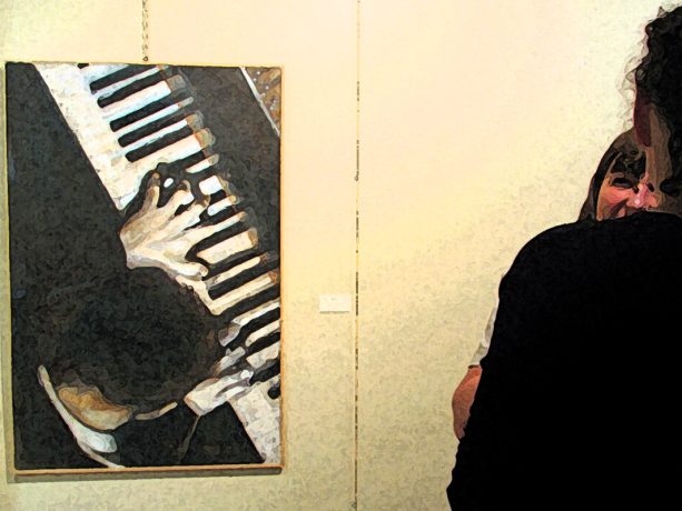 Uno scatto della mostra con un quadro della serie “orchestra” e una persona sulla sinistra